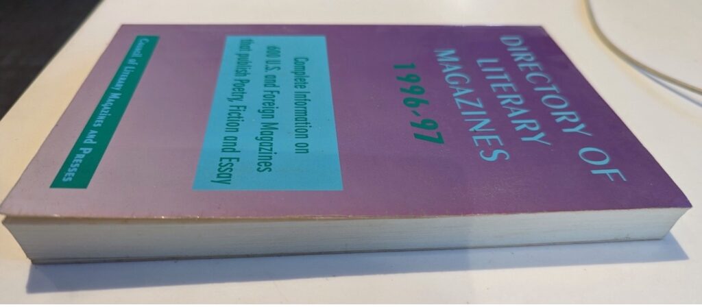 Photo of a 1996 issue of CLMP Directory of Literary Magazines. It has a purple cover, and light blue and green text.